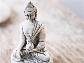 Close-up of small Buddha statue on table