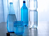 Blue mineral water bottle and glass of water