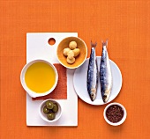 Canola oil, potatoes, pistachios, herring and flaxseed on orange background