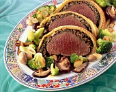 Beef fillet in puff pastry with mushroom stuffing on serving dish