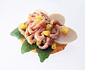 Close-up of mango, shrimp and hearts of palm on rice crackers on white background