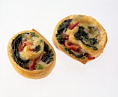 Close-up of teigschnecken pastry with spinach ham and cheese rolled on white background