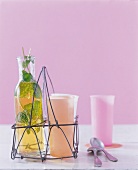 Elderberry lemonade with fresh mint drink in metal serve ware with spoons on table