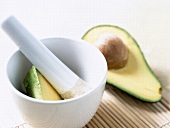 Close-up of mortar and pestle with halved avocado in it