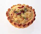 Appetizers of bacon tarts with bacon salami and gouda on pizza dough on white background