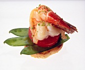 Close-up of king prawn with sweet peas and sesame baguette slice on white background
