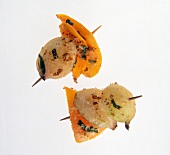 Close-up of shallots and pepper skewers on white background