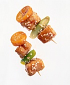 Asian skewers with chicken breast, kumquats, honey and chili on white background