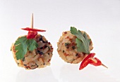 Close-up of rice balls with carrots, minced pork and chives on white background