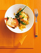 Salmon saltimbocca fried with prosciutto served with sage and risotto on plate