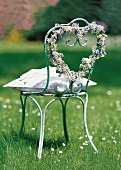 Chair decorated with flowers in heart shape in garden