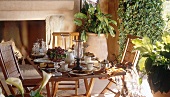 Laid table with colonial teak furniture on terrace