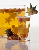 Exotic punch with garnishing of pineapple and star fruit in glass