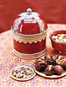 Orientalische Dose,daneben Teller mit Pistazien und gefüllten Datteln