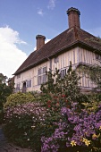 Colourful flowers against English house with two chimneys