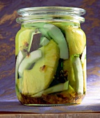 Slices of coconut, pineapple and brown sugar candy with coconut rum in glass jar