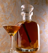 Ginger liqueur with walnuts in bulbous jar and martini glass