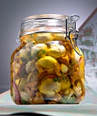 Sweet and sour pickled mushrooms, garlic and onions in glass jar