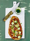 Pizza with zucchini, ham and mushrooms on white board