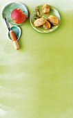 Potatoes, apple and knife on plate against green background, copy space