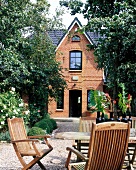 Exterior of house made of red brick with front garden area and furniture