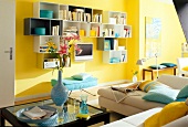 Different sizes of shelf boxes on yellow wall with flat television