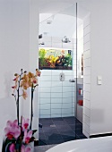 weiße gekachelte Trennwand zw Dusche und WC mit integriertem Aquarium
