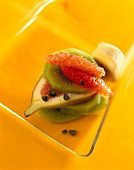 Close-up of fruit salad with grapefruit, orange, kiwi, figs and pistachios