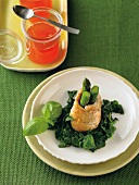 Close-up of turkey roulade with green asparagus and tomato jelly on plate