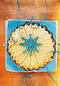 Christmas shortbread cake on blue paper, overhead view