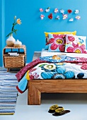 Teak wood bed with floral printed bedspread and cushions