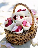 Close-up of basket of flowers and petals in paper bags