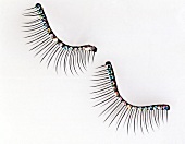 Artificial eyelashes with rhinestones placed on white background