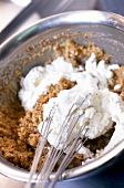 Close-up of cream being mixed with hazelnut paste in pot