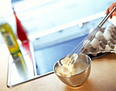 Eggs being whisked in bowl with whisk