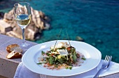 Salad with shrimp and carpaccio on plate