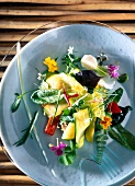 Salad with vegetables and flowers in bowl, overhead view