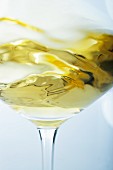 A glass of white wine being swirled