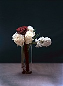 Hyacinth, red and white roses in glass bottle