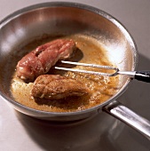Close-up of duck fillets being fried in pan