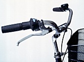 Close-up of adjustable handlebars and black basket on touring bike 