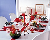 Table set festively with red and white decorations, apples and berries
