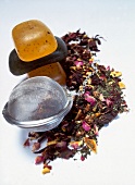 Bath herbs, tea soaps and tea infuser on white background
