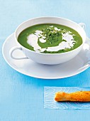 Pea soup with chives, horseradish cream and a puff pastry stick