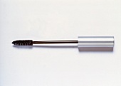 Close-up of mascara brush with silver cover placed on white background