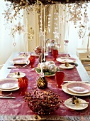 Banquet table set festively with pearl necklaces hanging above