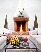 Living room with table between two white sofas in front of fireplace