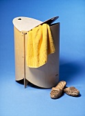 Wooden laundry container with slipper on blue background