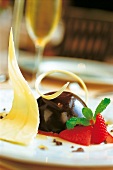 Close-up of chocolate ball with chicory and strawberries on plate
