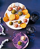 Colourful cookies and chocolates on a plate with glass of water